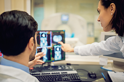 Two spine care specialists are looking at computer imaging.